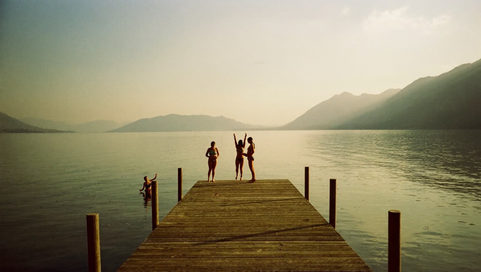 Friends on a wooden dock over a still lake